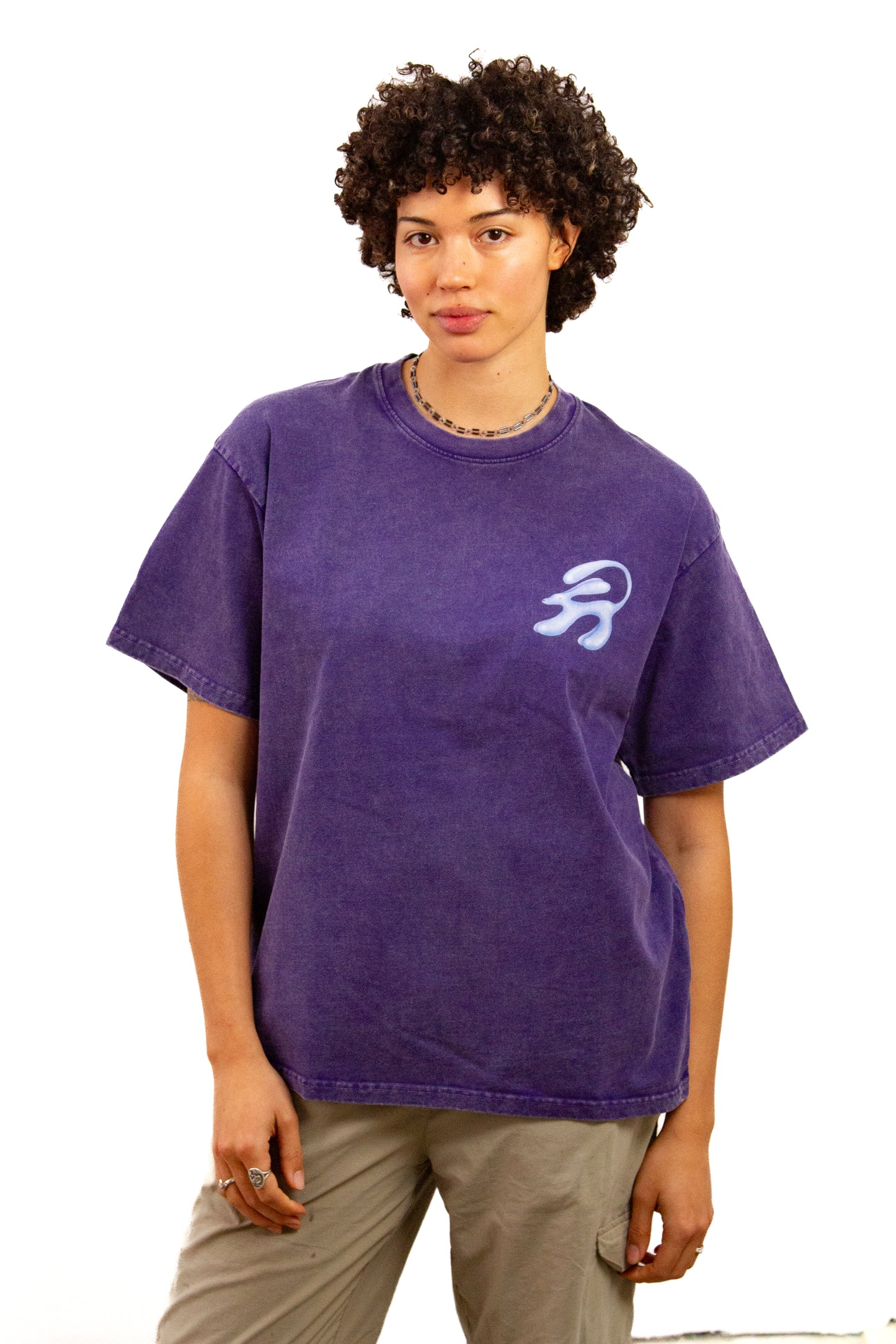 Light skinned androgynous model with natural curly hair wearing shirt in Amethyst
