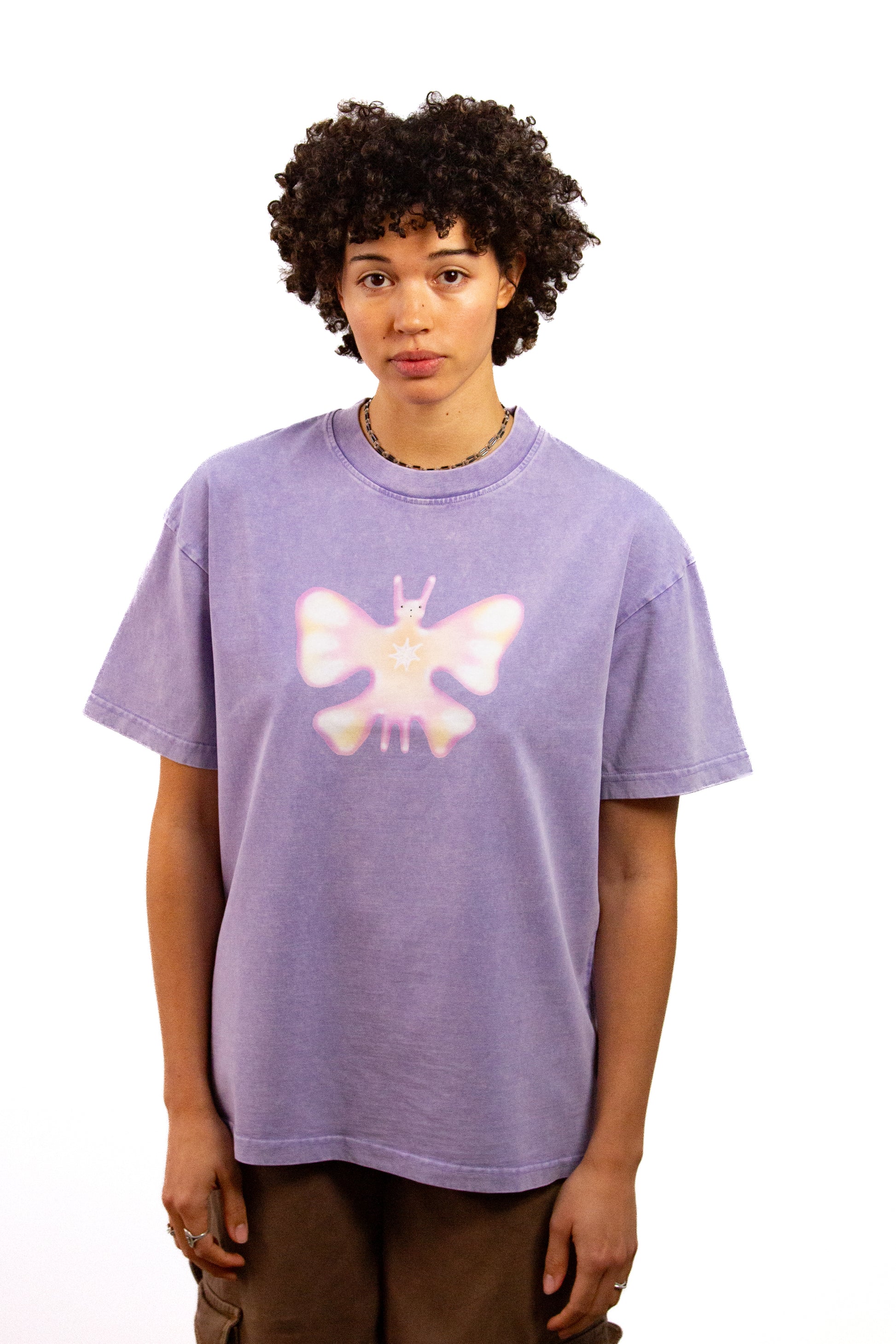 Light skinned androgynous model with natural curly hair wearing shirt in Lilac