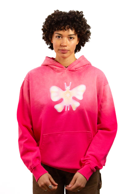 Light skinned androgynous model with natural curly hair wearing shirt in Starfruit pink