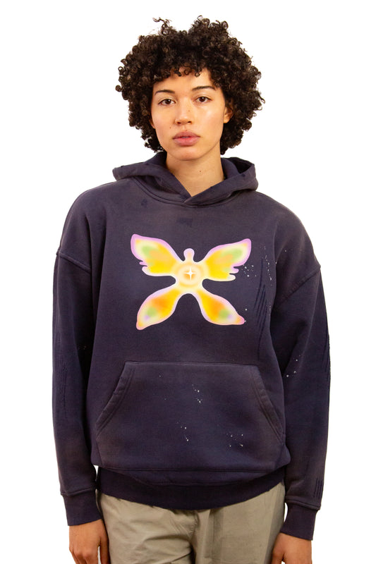 Light skinned androgynous model with natural curly hair wearing hoodie in Ink blue