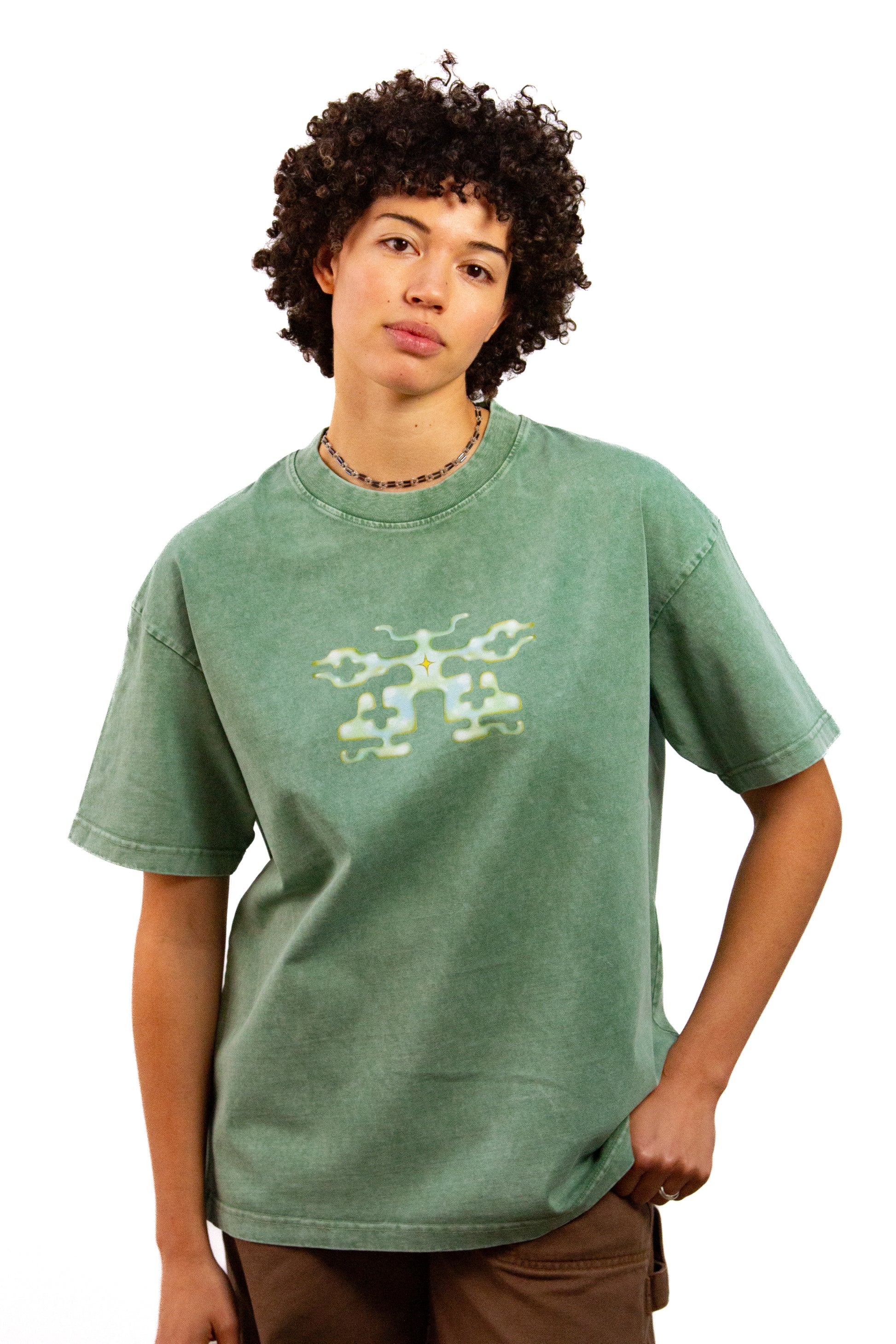 Light skinned androgynous model with natural curly hair wearing shirt in Mossmilk